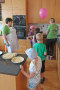 Kinder und zwei Erwachsene in Küche, auf Arbeitsplatte stehen Teller mit Pfannkuchen