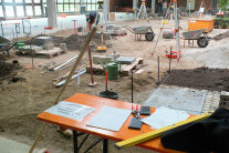 Auszubildende erstellenein Gewerk mit Erde, Steinen und Pflanzen.