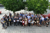 Die Absolventinnen und Absolventen sowie die Ehrengäste stellen sich zum Gruppenfoto auf.