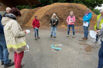 Personengruppe vor einem Getreidehaufen