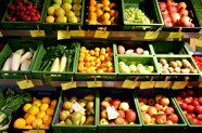 Obst und Gemüse in Kisten in einem Regal 